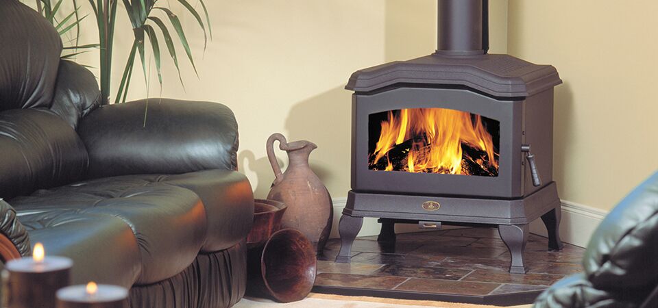 Kemlan C24 wood heater beside a black sofa adds warmth and comfort to a cosy living space, one of the best wood heaters for autumn