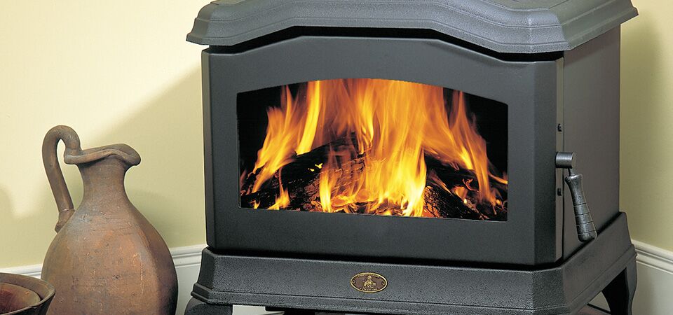 A black Kemlan C24 wood heater with a bright fire inside, one of the best wood heaters for autumn to keep homes warm