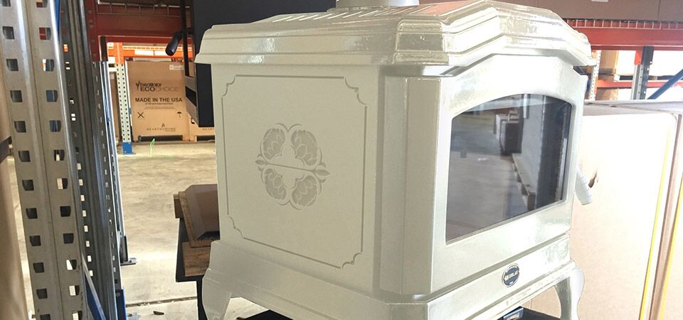 A white Kemlan C24 stove on a shelf with a compact, clean design, one of the best wood heaters for autumn home warmth