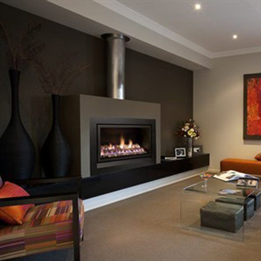 A living room with a Heatmaster Enviro 4 beside a decorative large black vases, one of the best gas fireplaces for autumn warmth