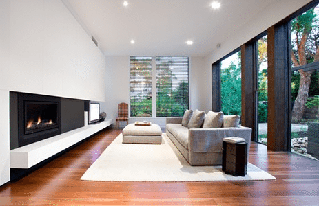 A Heatmaster Enviro Coals 2 fireplace adds cosy autumn warmth to a stylish living room with wooden floors and modern design