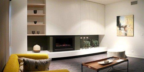 A Heatmaster Enviro Coals fireplace beside a yellow couch in a living room, one of the best gas fireplaces for autumn warmth