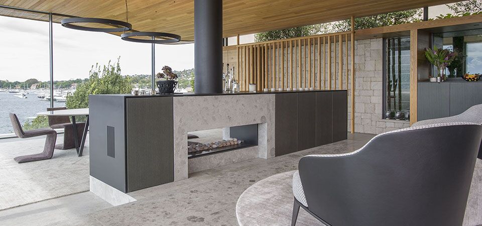 Modern kitchen with a picturesque water view and double-sided Horizon Low Line fireplace, one of the best gas log heaters for autumn