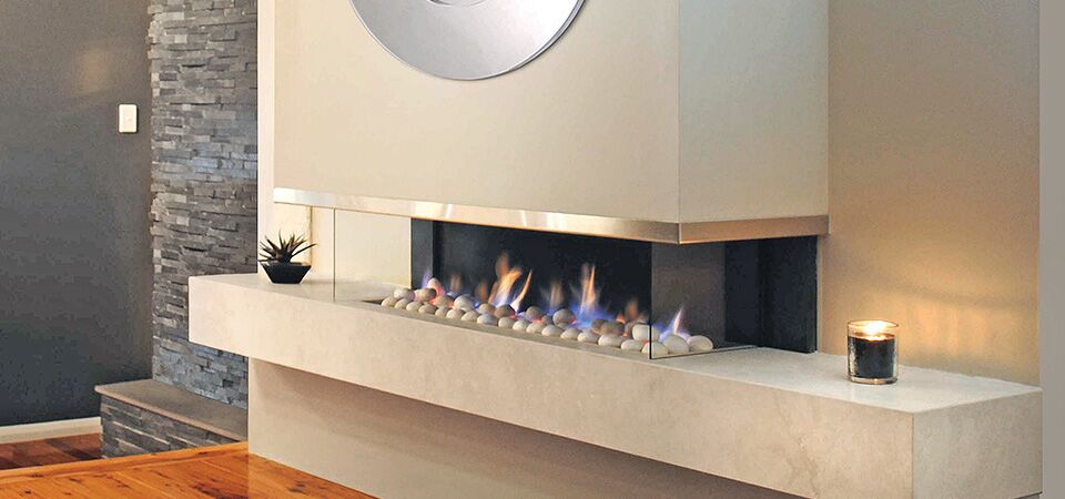 Modern gas log fires for homes with a Horizon Cantilever Fire beneath a round mirror, adding warmth and style to living space