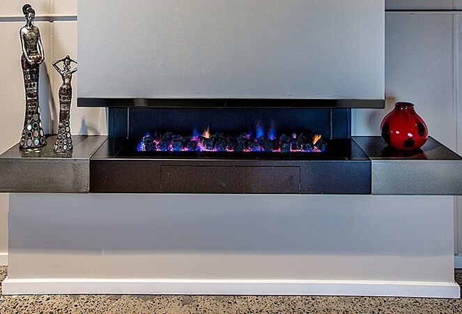 A modern Horizon Cantilever fireplace with a red vase beside it, one of the best gas log heaters for autumn interiors