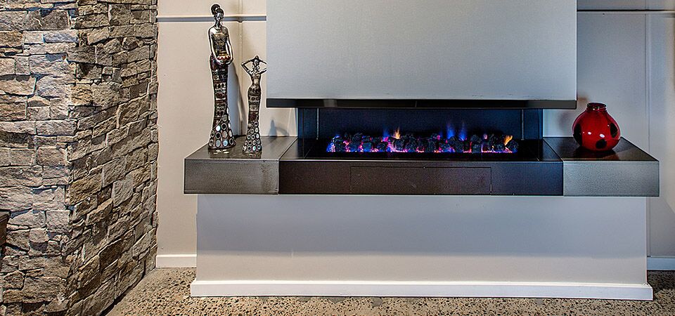 A modern Horizon Cantilever fireplace with a red vase beside it, one of the best gas log heaters for autumn interiors