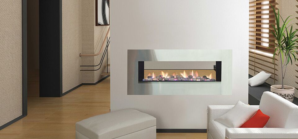 Horizon Low Line double-sided fireplace installed in a white wall beside a couch, among the best gas log heaters for autumn
