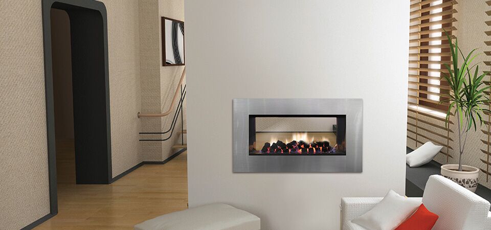 Horizon Low Line double-sided fireplace installed in a white wall beside a couch, among the best gas log heaters for autumn