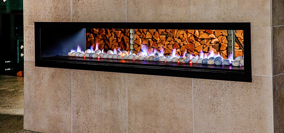 Modern Horizon Low Line double-sided fireplace set in a stone wall, one of the best gas log heaters for autumn warmth