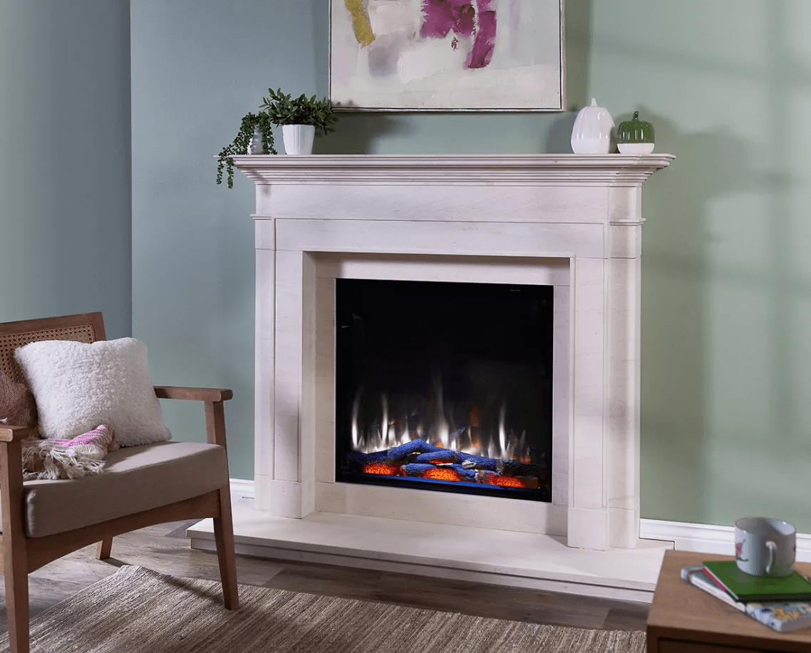 A Kemlan iRange i750e electric fireplace with a white mantle beside a cosy chair
