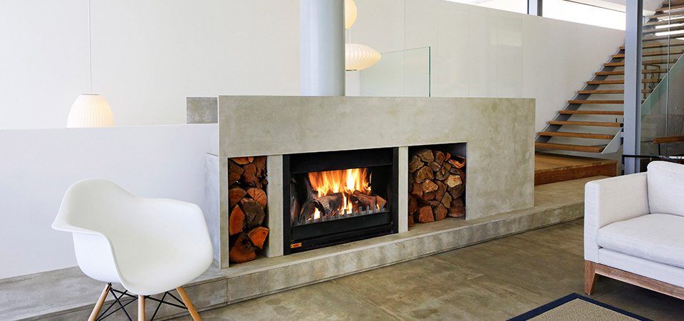 A Jetmaster Universal Inserts fireplace adds cosy autumn warmth and elegance to a stylish living room beside a staircase