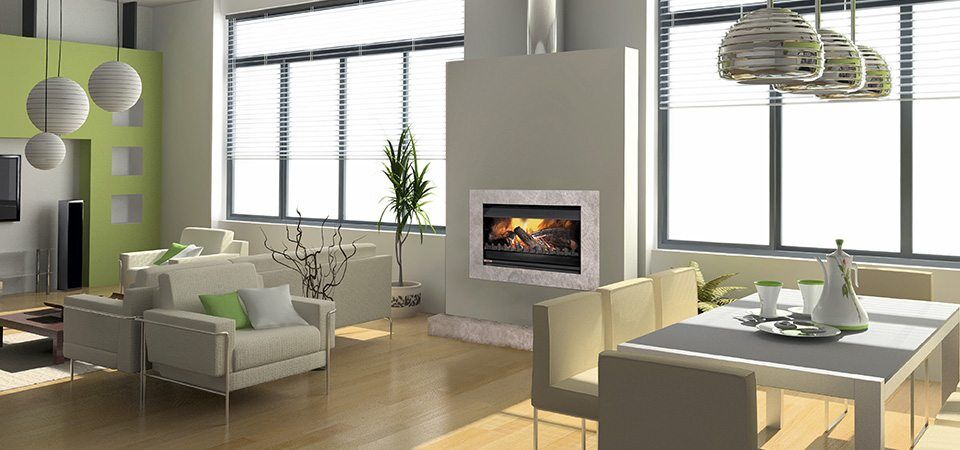 A modern living room with green walls, white furniture, and Jetmaster Universal Inserts, the best fireplaces for autumn warmth