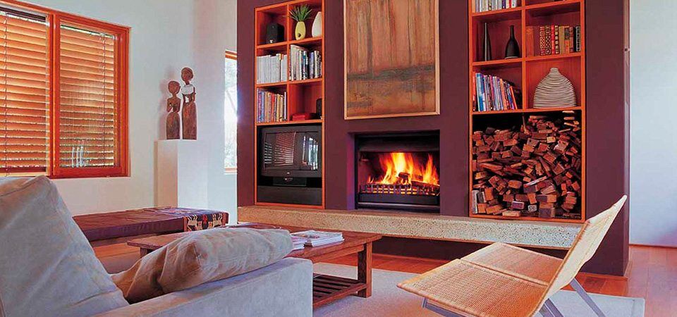 An inviting living room with a Jetmaster Universal Inserts fireplace and bookshelves lined with books and decorative items, offering the best fireplaces for autumn