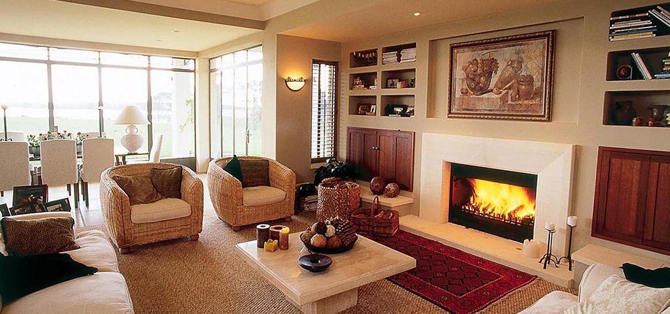 A modern living room with a Jetmaster Universal Inserts fireplace and plush couches, offering the best fireplaces for autumn warmth