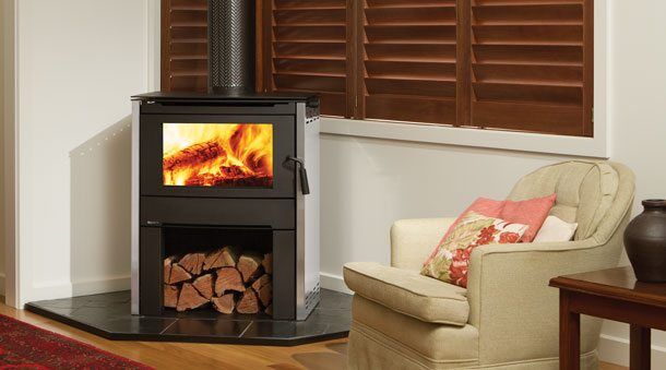 Regency Cardinia Medium Wood Freestanding stove in a cosy living room corner with a comfortable chair beside it, one of the best wood heaters for autumn warmth