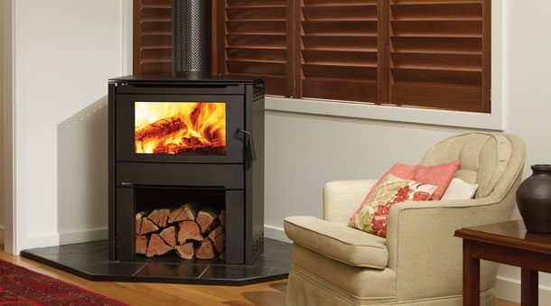 Regency Cardinia Medium Wood Freestanding stove in a cosy living room corner with a comfortable chair beside it, one of the best wood heaters for autumn warmth