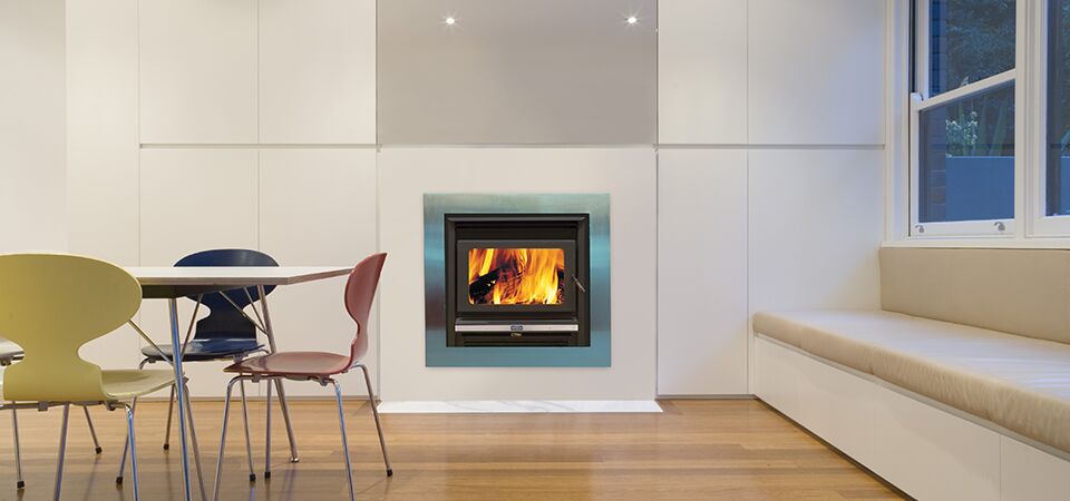 Kemlan Super Nova wood heater in a modern kitchen with colorful chairs, one of the best wood heaters for autumn warmth