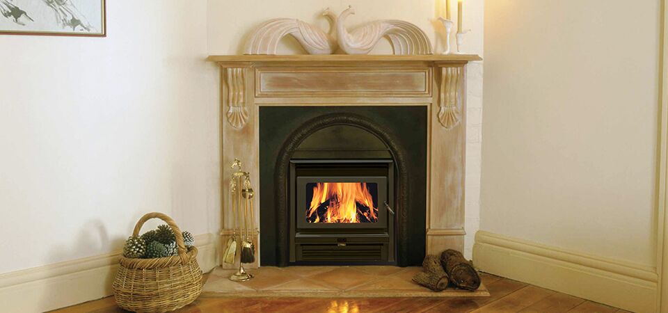 A Kemlan Super Nova wood burning stove in a cosy corner beside a basket, one of the best wood heaters for autumn creating a warm indoor space