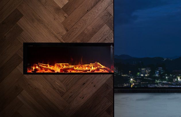 A VisionLINE View Electric Fireplace in a room with wood walls, featuring a panoramic view of the city skyline