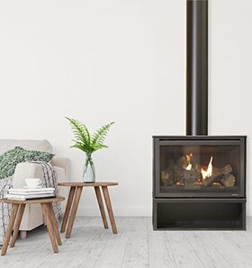 A simple living room with a Heat & Glo I30-X Freestanding wood burning stove, creating a warm atmosphere