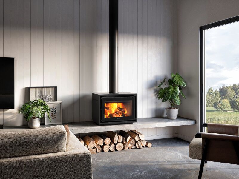 Stylish living room with indoor plant next to Regency Bondi Wood Heater Freestanding, adding warmth and comfort to the interior space