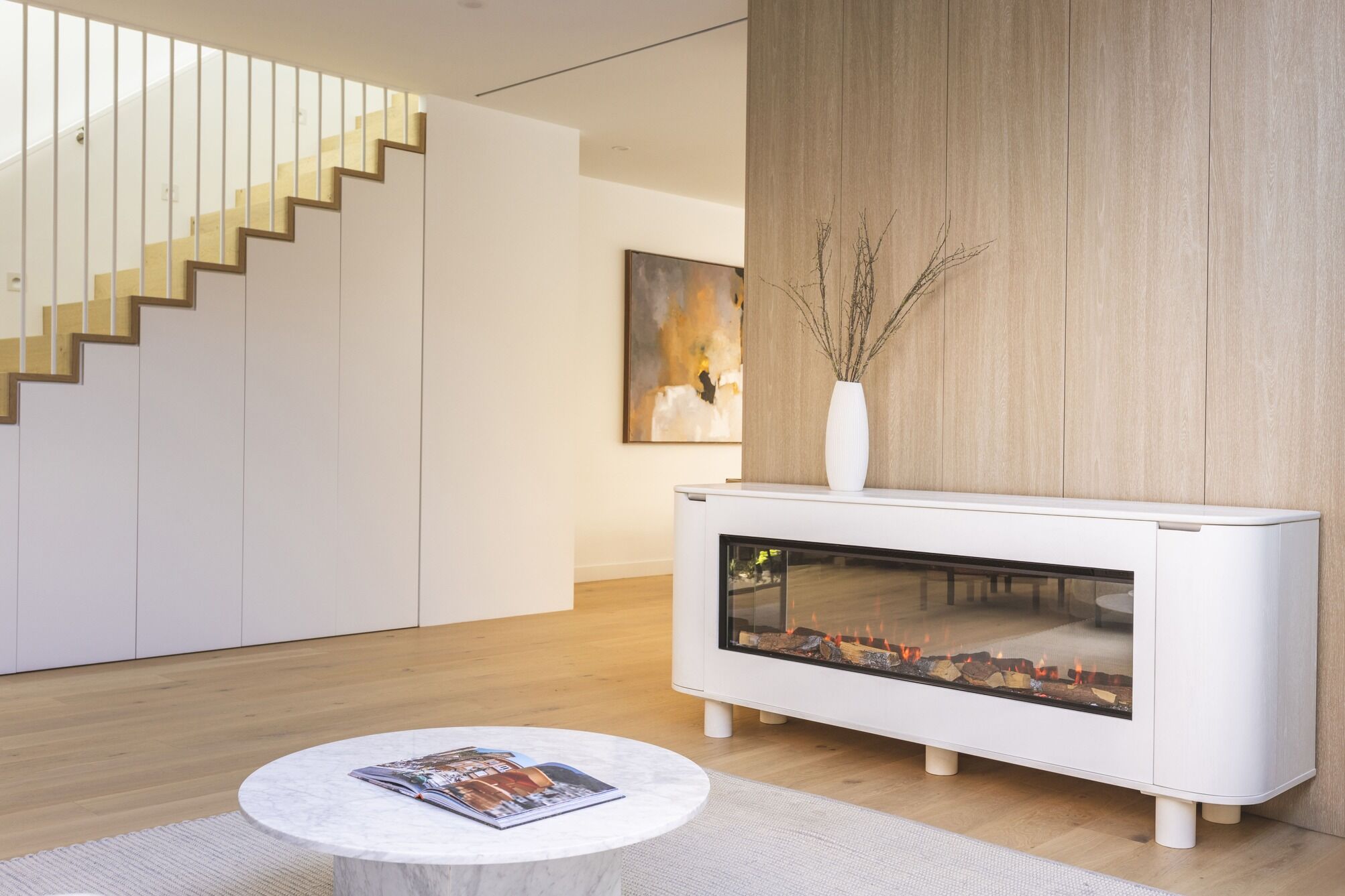 Ember Arc Grange 180 white electric fireplace in a contemporary home with a staircase that complements the modern interior design