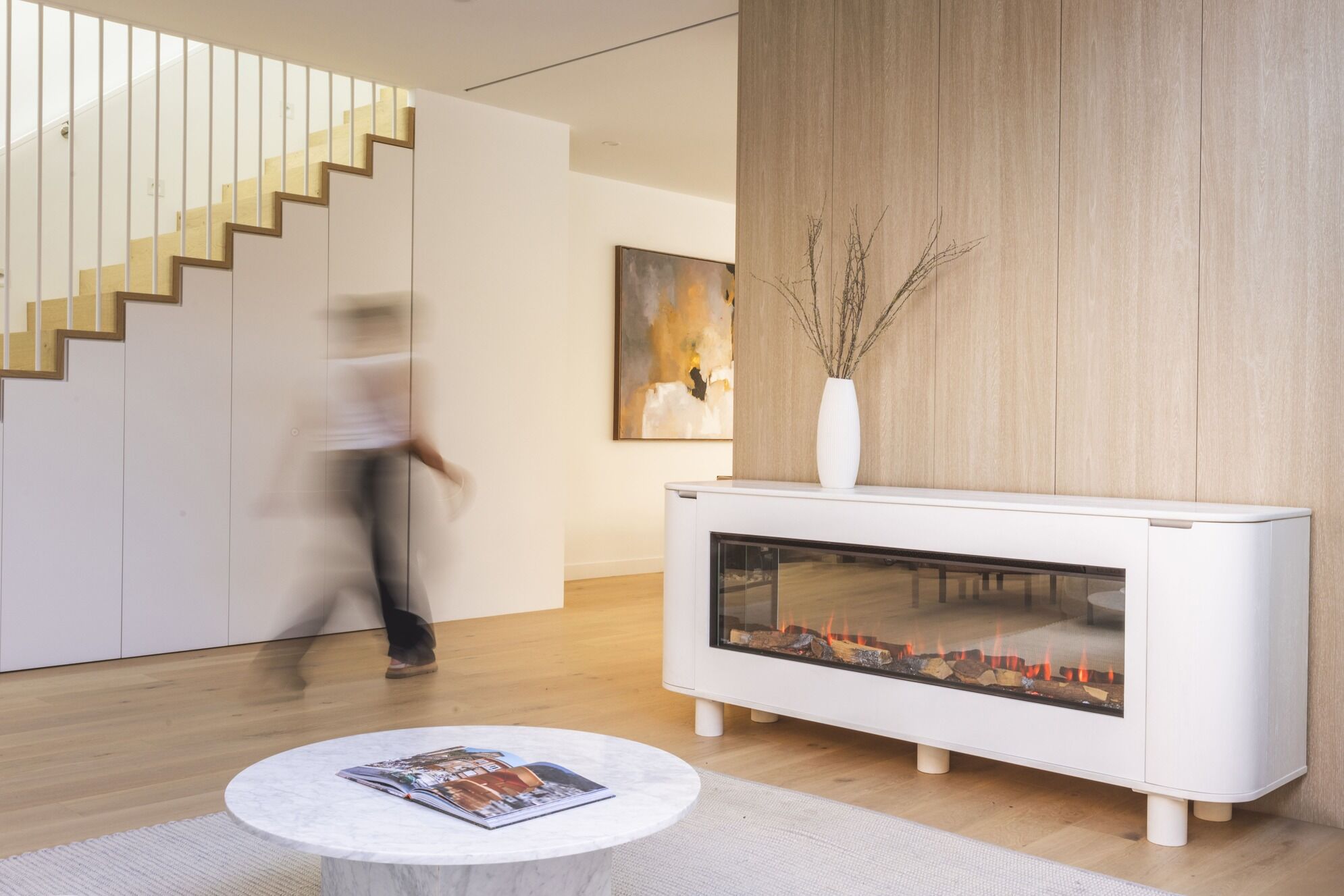 Ember Arc Grange 180 white electric fireplace in a contemporary home with a staircase that complements the modern interior design