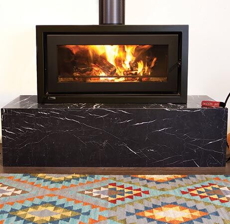 A Celestial Freestander wood burning stove warming a cosy room with a rug, one of the best wood heaters for autumn