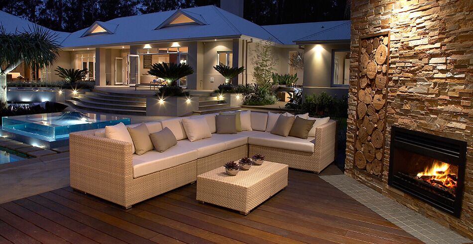 A cosy outdoor space with an Open Wood Fireplace and pool area, creating warmth and comfort with the best wood heaters for autumn