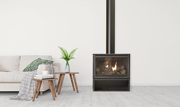A simple living room with a Heat & Glo I30-X Freestanding wood burning stove, creating a warm atmosphere