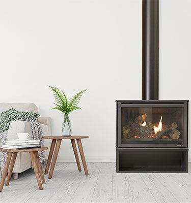 A simple living room with a Heat & Glo I30-X Freestanding wood burning stove, creating a warm atmosphere