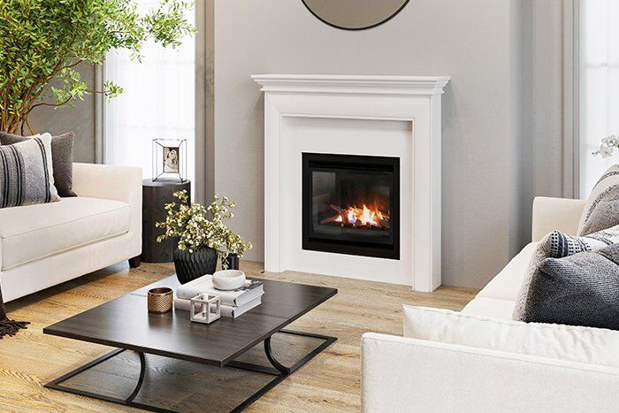 A cosy living room with a Real Flame Inspire Classic 600 gas fireplace insert and a plush couch for relaxation