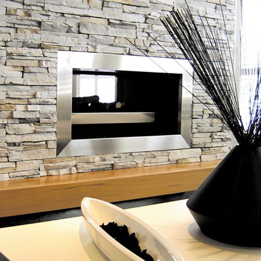 Modern gas log fires for homes with a Real Flame Double Vision fireplace on a stone wall, creating a cosy contemporary feel
