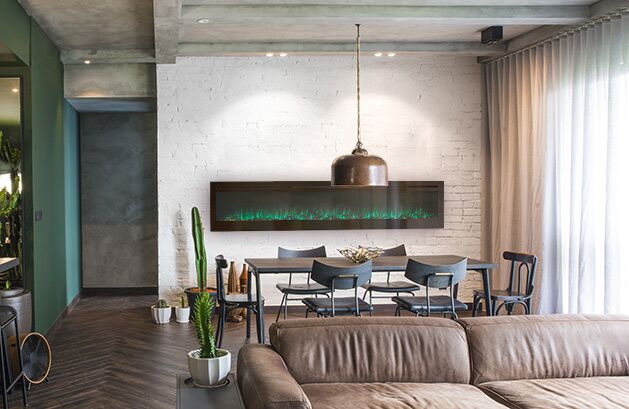 A stylish living room with a couch, table, and a modern VisionLINE Linear fireplace