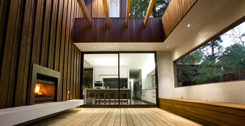 A modern home interior with a cosy Open Wood fireplace and warm wooden walls, a perfect example of the best wood heaters for autumn comfort
