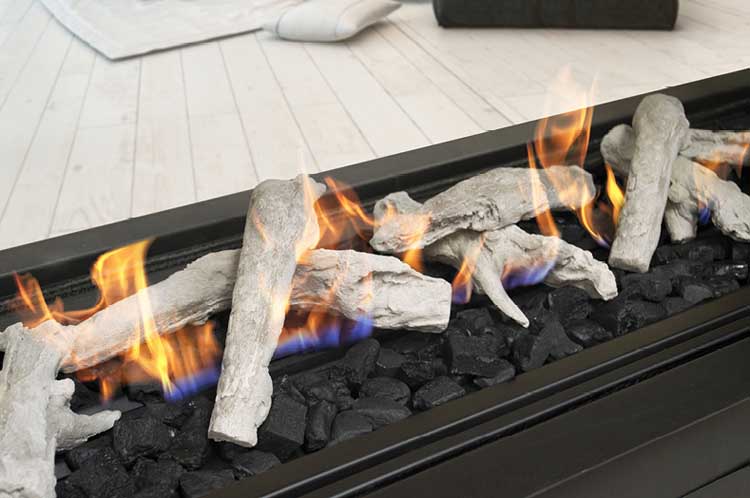 A Real Flame Element 1800 DS Gas Fire displaying logs and vibrant flames, enhanced by large black coals, providing a welcoming atmosphere