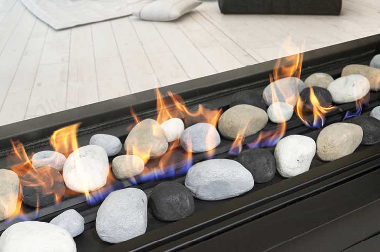 A Real Flame Element 1800 DS Gas Fire featuring a realistic fire with stones and large black coals, creating a warm ambiance
