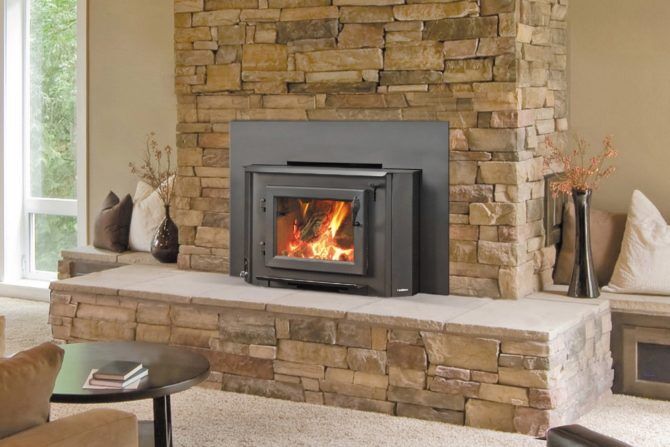A heatilator wood-burning stove insert installed in a brick wall, creating a cosy and warm atmosphere in the living space