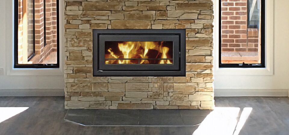 A Kemlan Celestial C900 fireplace with a vibrant fire burning brightly inside installed in a brick wall, one of the traditional wood fireplaces Melbourne