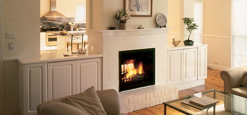 A modern living room with a Jetmaster Universal Double Sided fireplace, one of the best fireplaces for autumn warmth