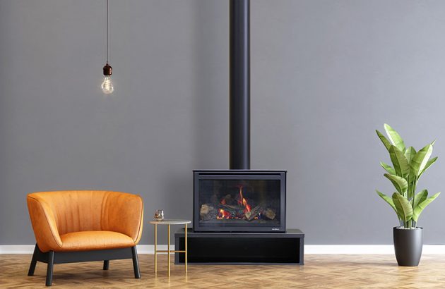 Heat & Glo i30-X freestanding Linear Bae fireplace with an orange chair and a potted plant beside it