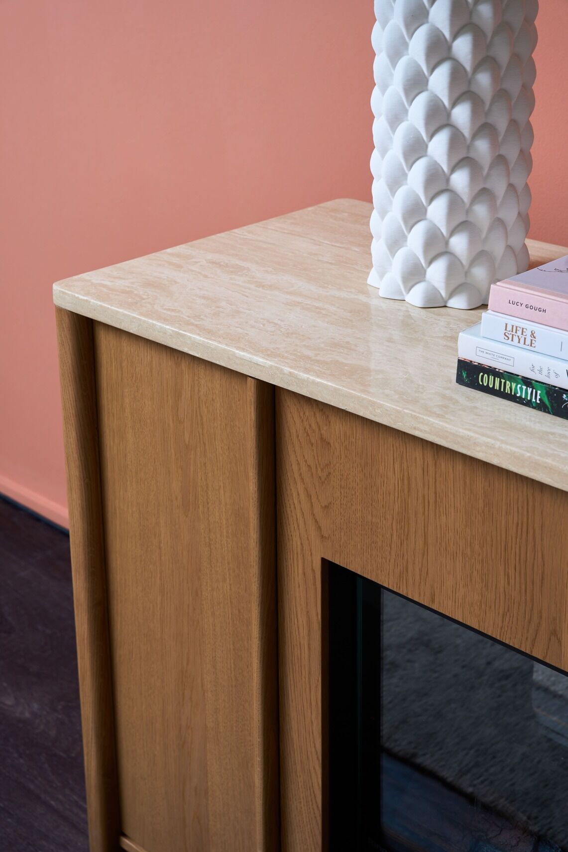 White vase on a wooden cabinet of Ember Arc Grange 180 electric fireplace in a cosy room with simple and elegant interior design
