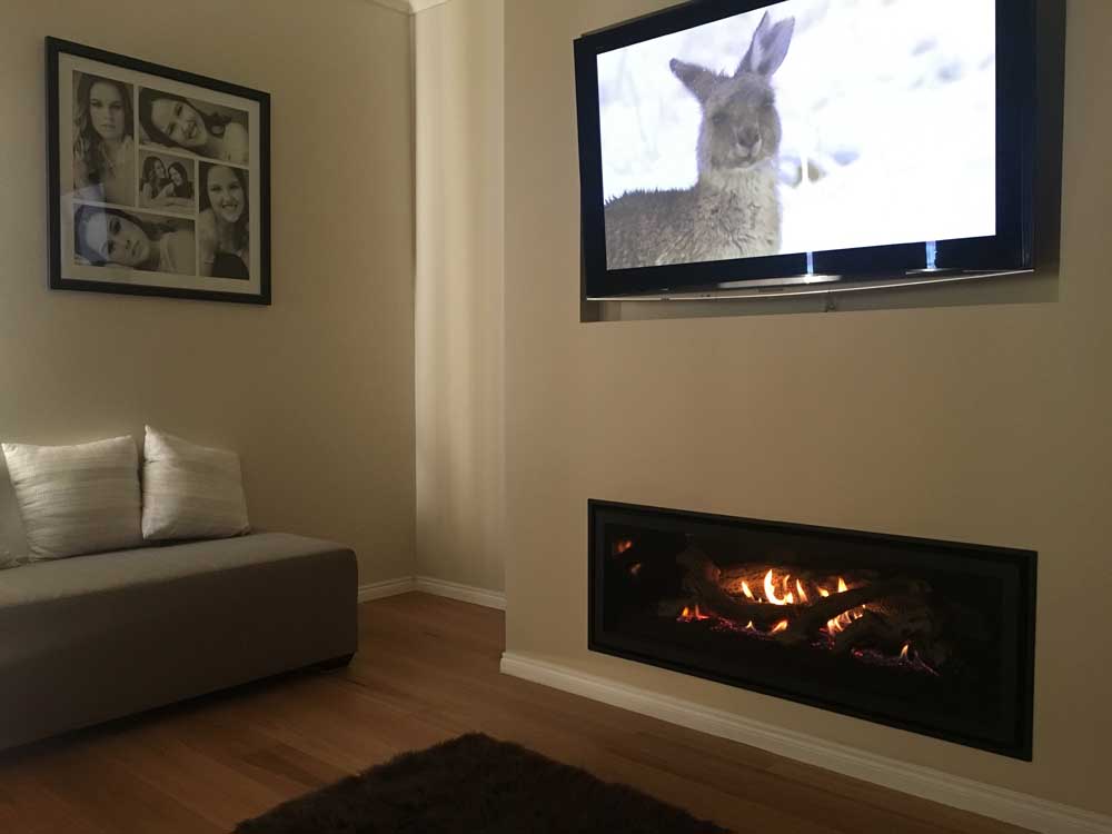 A stylish living room with a TV positioned above a Regency Greenfire GF1500L gas fire, enhancing the ambiance