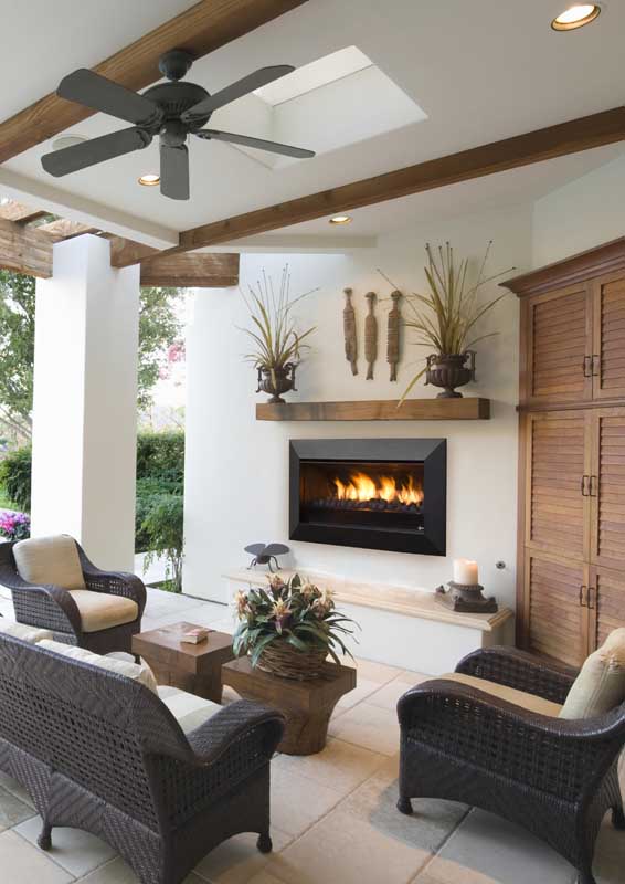 Outdoor patio with wicker seating and a Real Flame Exuro fireplace, offering warmth and style with modern gas log fires for homes