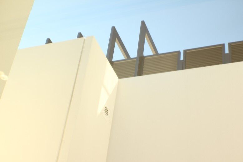 A white structure with a large window and metal pole equipped with a Power Flue System for modern gas log fires for homes