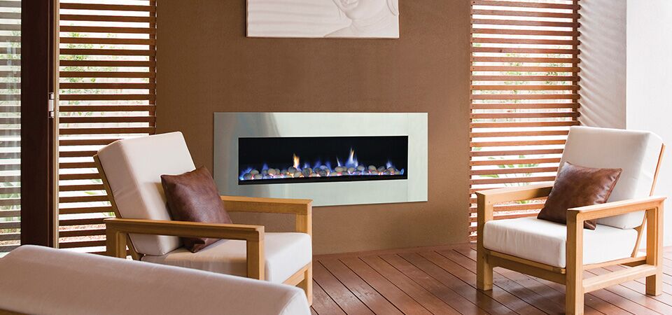 A cosy living room with a Horizon Low Line inbuilt fireplace and chairs, showing the best gas log heaters for autumn warmth
