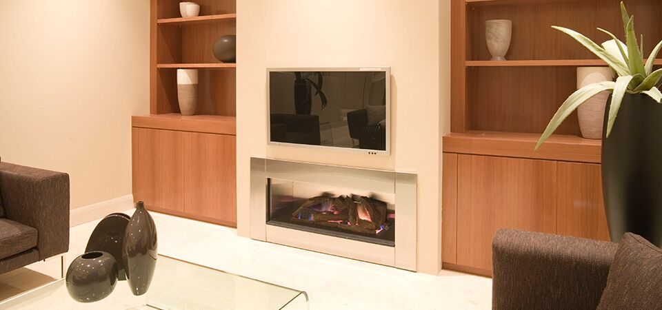 A Horizon Low Line Inbuilt Fireplace in a white mantle warming a cosy living room, among the best gas log heaters for autumn