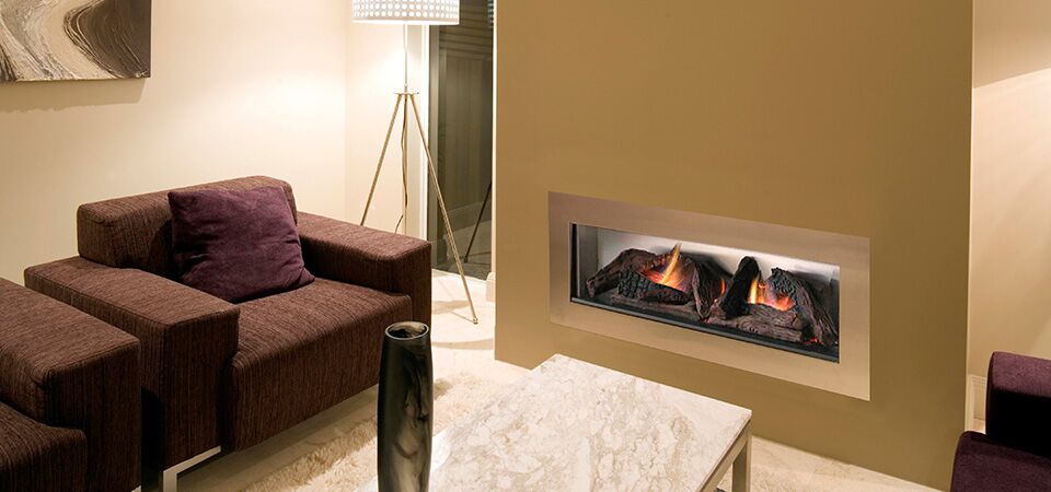 A plush couch and a Horizon Low Line Inbuilt Fireplace in a cosy living space, one of the best gas log heaters for autumn comfort and warmth