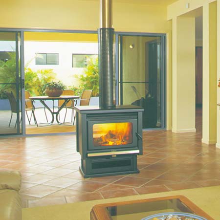 A cosy living room with a Kemlan Coupe Double Sided Freestander, one of the best wood heaters for autumn warmth