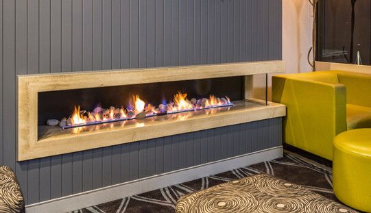 A modern living room with a Real Flame Hybrid Gas Log Fire, one of the best gas fireplaces for autumn warmth and comfort
